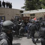 
              Israeli police confront with mourners as they carry the casket of slain Al Jazeera veteran journalist Shireen Abu Akleh during her funeral in east Jerusalem, Friday, May 13, 2022. Abu Akleh, a Palestinian-American reporter who covered the Mideast conflict for more than 25 years, was shot dead Wednesday during an Israeli military raid in the West Bank town of Jenin. (AP Photo/Mahmoud Illean)
            