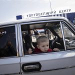 
              A child sits in a car as his family waits at a center for displaced people in Zaporizhzhia, Ukraine, Monday, May 2, 2022. (AP Photo/Evgeniy Maloletka)
            