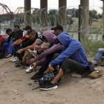 
              Migrants who had crossed the Rio Grande river into the U.S., remove their shoelaces and others personal items while under custody of National Guard members as they await the arrival of U.S. Border Patrol agents in Eagle Pass, Texas, Friday, May 20, 2022. As U.S. officials anxiously waited, many of the migrants crossing the border from Mexico on Friday were oblivious to a pending momentous court ruling on whether to maintain pandemic-related powers that deny a chance to seek asylum on grounds of preventing the spread of COVID-19. (AP Photo/Dario Lopez-Mills)
            