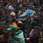 
              Palestinian mourners, some armed, carry the body of Amjad al-Fayyed, 17, during his funeral in the West Bank refugee camp of Jenin, Saturday, May 21, 2022. Israeli troops shot and killed al-Fayyed as fighting erupted when soldiers entered a volatile town in the occupied West Bank early Saturday, the Palestinian health ministry and local media said. (AP Photo/Majdi Mohammed)
            