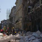 
              Emergency workers walk amid the rubble outside the five-star Hotel Saratoga after a deadly explosion in Old Havana, Cuba, Friday, May 6, 2022. (AP Photo/Ramon Espinosa)
            