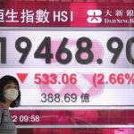 
              A woman wearing a face mask walks past a bank's electronic board showing the Hong Kong share index in Hong Kong, Tuesday, May 10, 2022. Asian stocks followed Wall Street lower Tuesday as fears increased that U.S. rate hikes to fight inflation might stall economic growth. (AP Photo/Kin Cheung)
            