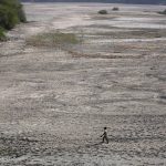 
              A man walks across an almost dried up bed of river Yamuna following hot weather in New Delhi, India, Monday, May 2, 2022. An unusually early and brutal heat wave is scorching parts of India, where acute power shortages are affecting millions as demand for electricity surges to record levels. (AP Photo/Manish Swarup)
            