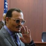 Actor Johnny Depp waves as he arrives in the courtroom at the Fairfax County Circuit Court in Fairfax, Va., Wednesday May 4, 2022. Depp sued his ex-wife Amber Heard for libel in Fairfax County Circuit Court after she wrote an op-ed piece in The Washington Post in 2018 referring to herself as a "public figure representing domestic abuse." (Elizabeth Frantz/Pool Photo via AP)
