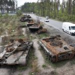 
              Cars pass by destroyed Russian tanks in a recent battle against Ukrainians in the village of Dmytrivka, close to Kyiv, Ukraine, Monday, May 23, 2022. (AP Photo/Efrem Lukatsky)
            