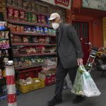
              An elderly man carries his shopping in front of a grocery store in Tehran, Iran, Wednesday, May 11, 2022. Iran abruptly raised prices as much as 300% for a variety of staples such as cooking oil, chicken, eggs and milk on Thursday. (AP Photo/Vahid Salemi)
            