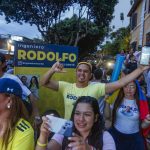 
              Supporters of Rodolfo Hernandez, presidential candidate with the Anti-corruption Governors League, celebrate as they listen to favorable partial results at his election night headquarters in Bucaramanga, Colombia, Sunday, May 29, 2022. Hernandez will advance to a runoff contest in June after none of the six candidates in Sunday's first round got half the vote. (AP Photo/Mauricio Pinzon)
            