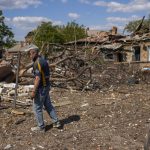 
              A local resident stands next to a house destroyed in a Russian bombing in Bakhmut, eastern Ukraine, Tuesday, May 24, 2022. The town of Bakhmut has been coming under increasing artillery strikes, particularly over the last week, as Russian forces try to press forward to encircle the city of Sieverodonetsk to the northeast. (AP Photo/Francisco Seco)
            