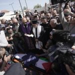 
              Christian priests pray over the body of Al Jazeera journalist Shireen Abu Akleh, surrounded by other journalists, in the West Bank town of Jenin, Wednesday, May 11, 2022. The well-known Palestinian reporter for the broadcaster's Arabic language channel was shot and killed while covering an Israeli raid in the occupied West Bank town of Jenin early Wednesday. (AP Photo/Majdi Mohammed)
            