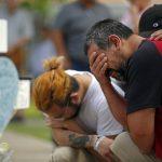 
              Vincent Salazar, right, father of Layla Salazar, weeps while kneeling in front of a cross with his daughter's name at a memorial site for the victims killed in this week's elementary school shooting in Uvalde, Texas, Friday, May 27, 2022. (AP Photo/Dario Lopez-Mills)
            