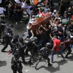
              Israeli police confront with mourners as they carry the casket of slain Al Jazeera veteran journalist Shireen Abu Akleh during her funeral in east Jerusalem, Friday, May 13, 2022. Abu Akleh, a Palestinian-American reporter who covered the Mideast conflict for more than 25 years, was shot dead Wednesday during an Israeli military raid in the West Bank town of Jenin. (AP Photo/Maya Levin)
            