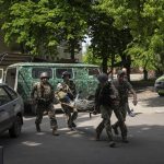 
              Ukrainian servicemen carry their injured comrade on stretcher to the hospital after an attack by Russian forces in Donetsk region, Ukraine, on Monday, May 9, 2022.(AP Photo/Evgeniy Maloletka)
            