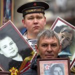 
              People carry portraits of relatives who fought in World War II, during the Immortal Regiment march in Ulan-Ude, the regional capital of Buryatia, a region near the Russia-Mongolia border, Russia, Monday, May 9, 2022, marking the 77th anniversary of the end of World War II. (AP Photo)
            