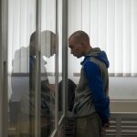 
              Russian Sgt. Vadim Shishimarin stands in court during a hearing in Kyiv, Ukraine, Thursday, May 19, 2022. The 21 year old Russian soldier facing the first war crimes trial since the start of the war in Ukraine testified Thursday that he shot a civilian on orders from two officers and pleaded for his victim's widow to forgive him. (AP Photo/Roman Hrytsyna)
            