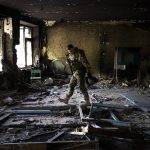 
              A Ukrainian serviceman inspects a school damaged during a battle between Russian and Ukrainian forces in the village of Vilkhivka, on the outskirts of Kharkiv, in eastern Ukraine, Friday, May 20, 2022. (AP Photo/Bernat Armangue)
            