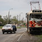 
              A man pushes a stalled car past a damaged tram in Mariupol, in territory under the government of the Donetsk People's Republic, eastern Ukraine, Saturday, May 21, 2022. (AP Photo/Alexei Alexandrov)
            