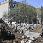 
              A worker stands next to a crater of an explosion next to an apartment building damaged by night shelling in Kramatorsk, Ukraine, Thursday, May 5, 2022. (AP Photo/Andriy Andriyenko)
            