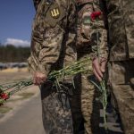 
              Irpin Territorial Defence and Ukrainian Army soldiers hold flowers to be placed on the graves of fallen comrades during the Russian occupation, at the cemetery of Irpin, on the outskirts of Kyiv, on Sunday, May 1, 2022. (AP Photo/Emilio Morenatti)
            