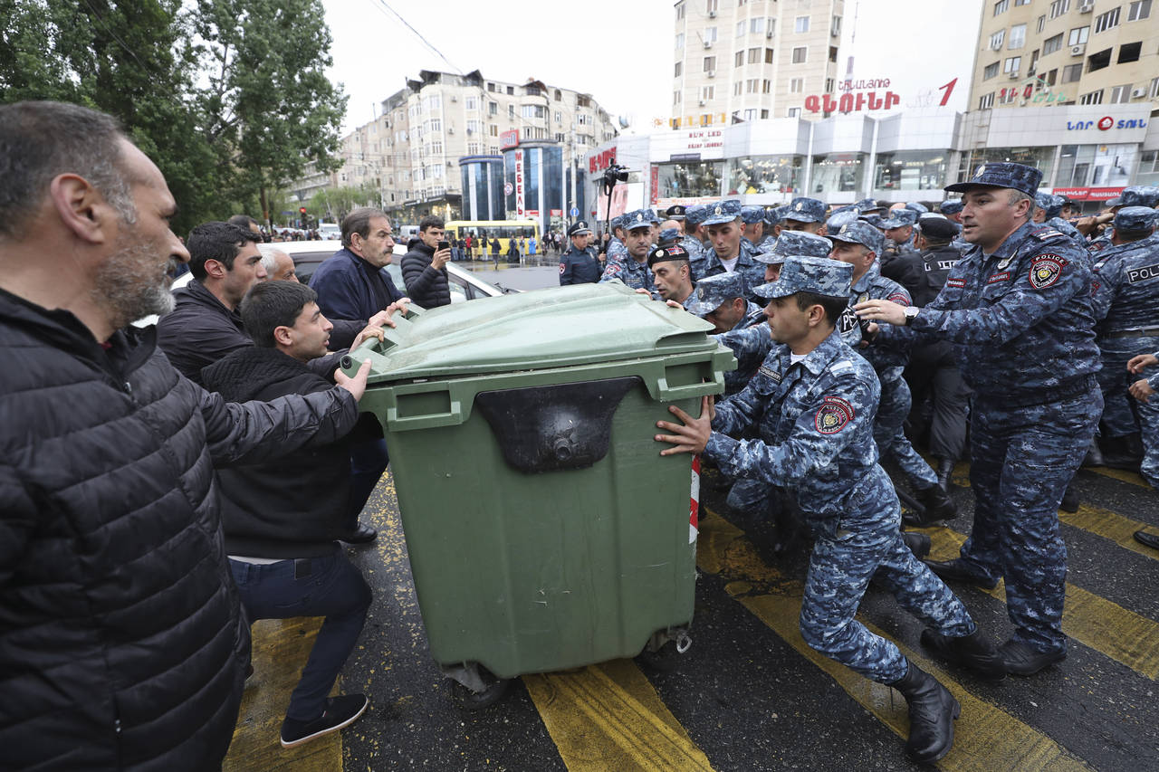 Police clash with demonstrators during a protest rally, in Yerevan, Armenia, Monday, May 2, 2022. P...