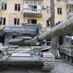 
              Tanks of Donetsk People's Republic militia stand next to a damaged apartment building in Mariupol, in territory under the government of the Donetsk People's Republic, eastern Ukraine, Wednesday, May 4, 2022. (AP Photo/Alexei Alexandrov)
            