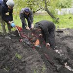 
              Police and volunteers exhume the bodies of civilians killed by Russian shelling in the village of Stepaky, close to Kharkiv, Ukraine, Wednesday, May 11, 2022. (AP Photo/Andrii Marienko)
            