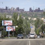 
              A view of a street in Mariupol, in territory under the government of the Donetsk People's Republic, eastern Ukraine, Tuesday, May 17, 2022, with the Azovstal steel plant in the background. (AP Photo/Alexei Alexandrov)
            