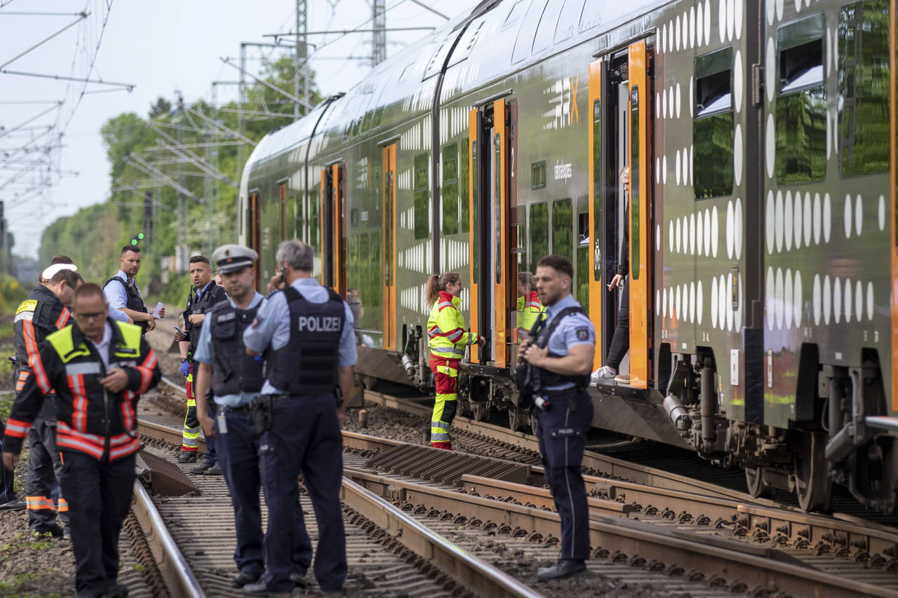 Police officers standing in front of a regional train in Herzogenrath, Germany, Friday, May 13, 202...