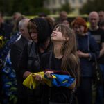 
              Shufryn Lilia, 17, cries next to the coffin of her father Shufryn Andriy, 41, a Ukrainian military servicemen who was killed in the east, during his funeral in Lviv, Ukraine, Saturday, May 14, 2022. (AP Photo/Emilio Morenatti)
            