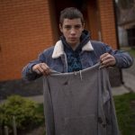 
              Yura Nechyporenko, 15, holds the hoodie he was wearing the day a Russian soldier tried to kill him in Bucha, on the outskirts of Kyiv, Ukraine, on Tuesday, April 19, 2022. His father was killed, and now his family seeks justice. The hoodie, bloodied at the elbow where a bullet had pierced him, is now the centerpiece of the family's search for justice. Yura's mother, Alla, insisted that it not be thrown away. (AP Photo/Emilio Morenatti)
            
