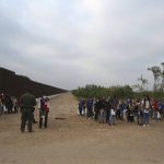 
              A Border Patrol agent instructs migrants who had crossed the Rio Grande river into the U.S. in Eagle Pass, Texas, Friday, May 20, 2022. As U.S. officials anxiously waited, many of the migrants crossing the border from Mexico on Friday were oblivious to a pending momentous court ruling on whether to maintain pandemic-related powers that deny a chance to seek asylum on grounds of preventing the spread of COVID-19. (AP Photo/Dario Lopez-Mills)
            