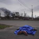 
              FILE - A body lies covered by a tarp in the street in Mariupol, Ukraine, March 7, 2022. (AP Photo/Evgeniy Maloletka, File)
            