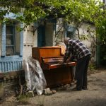 
              Local resident Anatolii Virko plays a piano outside a house likely damaged after a Russian bombing in Velyka Kostromka village, Ukraine, Thursday, May 19, 2022. (AP Photo/Francisco Seco)
            