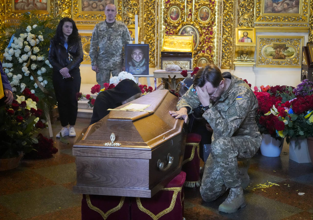 A soldier pays his last tribute to volunteer soldier Oleksandr Makhov, 36, a well-known Ukrainian j...