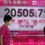 
              A woman wearing a face mask walks past a bank's electronic board showing the Hong Kong share index in Hong Kong, Wednesday, May 18, 2022. Asian stock markets were mixed Wednesday after Wall Street rose and the Federal Reserve chairman said it will raise interest rates further if needed to cool inflation.(AP Photo/Kin Cheung)
            