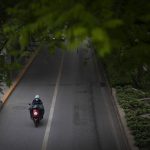 
              A person wearing a face mask rides along a street in the central business district in Beijing during what is normally the morning rush hour, as most nonessential workers in the district have been ordered to work from home, Tuesday, May 10, 2022. Teams in white protective suits are going into the homes of infected people to spray them with disinfectant as Shanghai tries to root out an omicron outbreak under China's strict "zero-COVID" strategy. Beijing, the capital, began another round of three days of mass testing for millions of its residents Tuesday in a bid to prevent an outbreak from growing to Shanghai proportions. (AP Photo/Mark Schiefelbein)
            