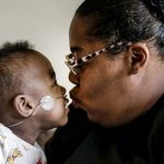 
              Curtis Means kisses his mother, Michelle Butler at their home in Eutaw, Ala., on Wednesday, March 23, 2022. Butler was just over halfway through her pregnancy when her water broke and contractions wracked her body. She couldn’t escape a terrifying truth: Her twins were coming much too soon. (AP Photo/Butch Dill)
            