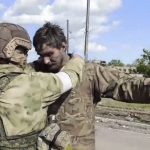 
              In this photo taken from video released by the Russian Defense Ministry on Friday, May 20, 2022, a Russian serviceman frisks a Ukrainian serviceman after they leaved the besieged Azovstal steel plant in Mariupol, in territory under the government of the Donetsk People's Republic, eastern Ukraine. (Russian Defense Ministry Press Service via AP)
            