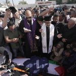 
              Christian priests pray over the body of Al Jazeera journalist Shireen Abu Akleh, surrounded by other journalists, in the West Bank town of Jenin, Wednesday, May 11, 2022. The well-known Palestinian reporter for the broadcaster's Arabic language channel was shot and killed while covering an Israeli raid in the occupied West Bank town of Jenin early Wednesday. (AP Photo/Majdi Mohammed)
            