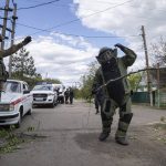 
              A de-miner wearing protective gear works in an area where unexploded devices were found after shelling of Russian forces in Maksymilyanivka, Ukraine, Tuesday, May 10, 2022. (AP Photo/Evgeniy Maloletka)
            