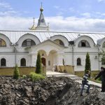 
              Orthodox Sister Evdokia, right, helps Maxim to come up from the crater of an explosion, after Russian shelling next to the Orthodox Skete in honor of St. John of Shanghai in Adamivka, near Slovyansk, Donetsk region, Ukraine, Tuesday, May 10, 2022. (AP Photo/Andriy Andriyenko)
            