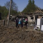 
              People react as they stand next to a crater in destroyed residential area after Russian airstrike in Bakhmut, Donetsk region, Ukraine, Saturday, May 7, 2022. (AP Photo/Evgeniy Maloletka)
            
