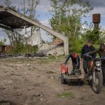 
              Villagers collect scrap metal from a shelled warehouse in the village of Malaya Rohan, Kharkiv region, Wednesday, May 18, 2022. (AP Photo/Bernat Armangue)
            