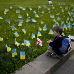 
              A boy watches flags honoring soldiers killed fighting Russian troops in downtown Kyiv, Ukraine, Monday, May 23, 2022. (AP Photo/Natacha Pisarenko)
            