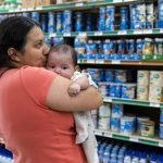 
              Yury Navas, 29, of Laurel, Md., kisses her two-month-old baby Jose Ismael Gálvez, at Superbest International Market in Laurel, Md., Monday, May 23, 2022, while looking for formula. After this day's feedings she will be down to the last 12.5 ounce container. The only formula he can take without digestive issues, Enfamil Infant, has been almost impossible for her to find. Navas doesn't know why her breastmilk didn't come in for her third baby and has tried many brands of formula before finding the one kind that he could tolerate. Though the baby food aisle had plenty of options for older babies, the kind she needs was nowhere in sight. (AP Photo/Jacquelyn Martin)
            