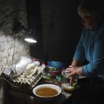 
              An Ukrainian woman washes dishes in the basement of a building used as bomb shelter in Soledar, Donetsk region, Ukraine, Tuesday, May 24, 2022. (AP Photo/Andriy Andriyenko)
            