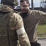 
              In this photo taken from a video released by the Russian Defense Ministry Press Service on Wednesday, May 18, 2022, a Russian serviceman frisks a Ukrainian soldier after he left the besieged Azovstal steel plant in Mariupol, Ukraine. (Russian Defense Ministry Press Service via AP)
            