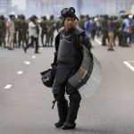 
              A Sri Lankan policeman stands guard in riot gear during clashes between anti-government protesters and government supporters in Colombo, Sri Lanka, Monday, May 9, 2022. Authorities deployed armed troops in the capital Colombo on Monday hours after government supporters attacked protesters who have been camped outside the offices of the country's president and prime minster, as trade unions began a “Week of Protests” demanding the government change and its president to step down over the country’s worst economic crisis in memory. (AP Photo/Eranga Jayawardena)
            
