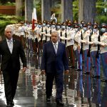 
              Cuba's President Miguel Diaz Canel, left, and Mexican President Andres Manuel Obrador, center, review the honor guard at the Revolution Palace in Havana, Cuba, Sunday, May 8, 2022. (Yamil Lage/Pool Photo via AP)
            