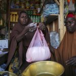 
              Halimo Hersi, 42, right, buys wheat flour from a shopkeeper in the Hamar-Weyne market in the capital Mogadishu, Somalia Thursday, May 26, 2022. Families across Africa are paying about 45% more for wheat flour as Russia's war in Ukraine blocks exports from the Black Sea. Some countries like Somalia get more than 90% of their wheat from Russia and Ukraine. That's forcing many people to substitute wheat for other grains. But the United Nations is warning that the price hikes are coming as many parts of Africa are facing drought and hunger. (AP Photo/Farah Abdi Warsameh)
            
