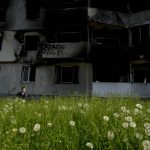 
              A boy runs in front of a building destroyed by attacks in Borodyanka, on the outskirts of Kyiv, Ukraine, Tuesday, May 31, 2022. (AP Photo/Natacha Pisarenko)
            